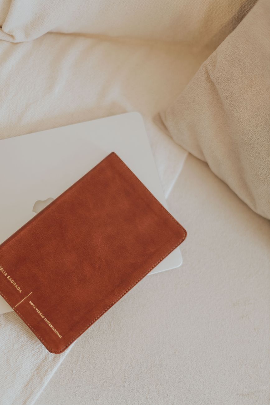Person studying the Bible on a laptop with notes and coffee