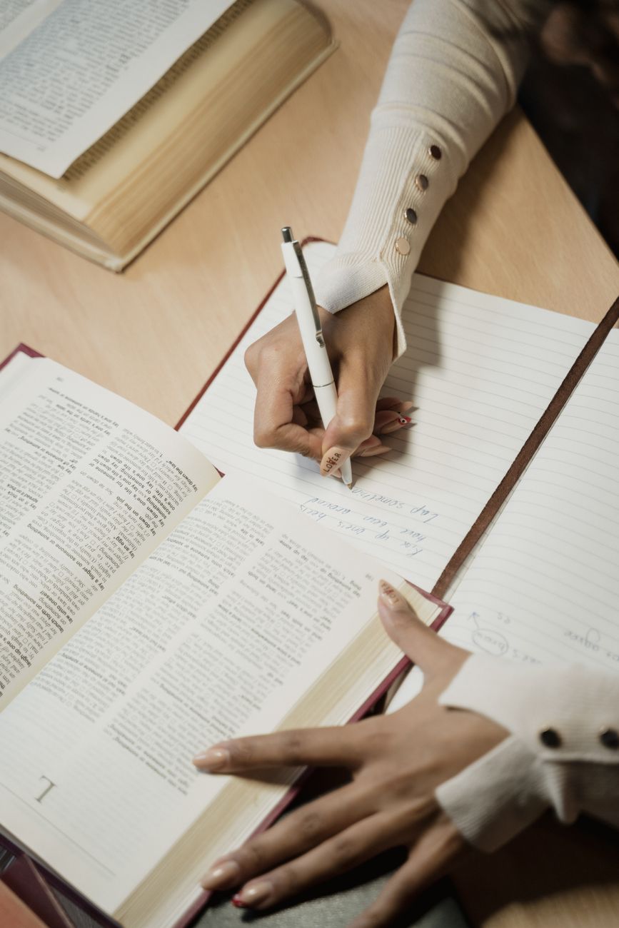 Open Bible with cross reference notes and highlighter on a wooden desk