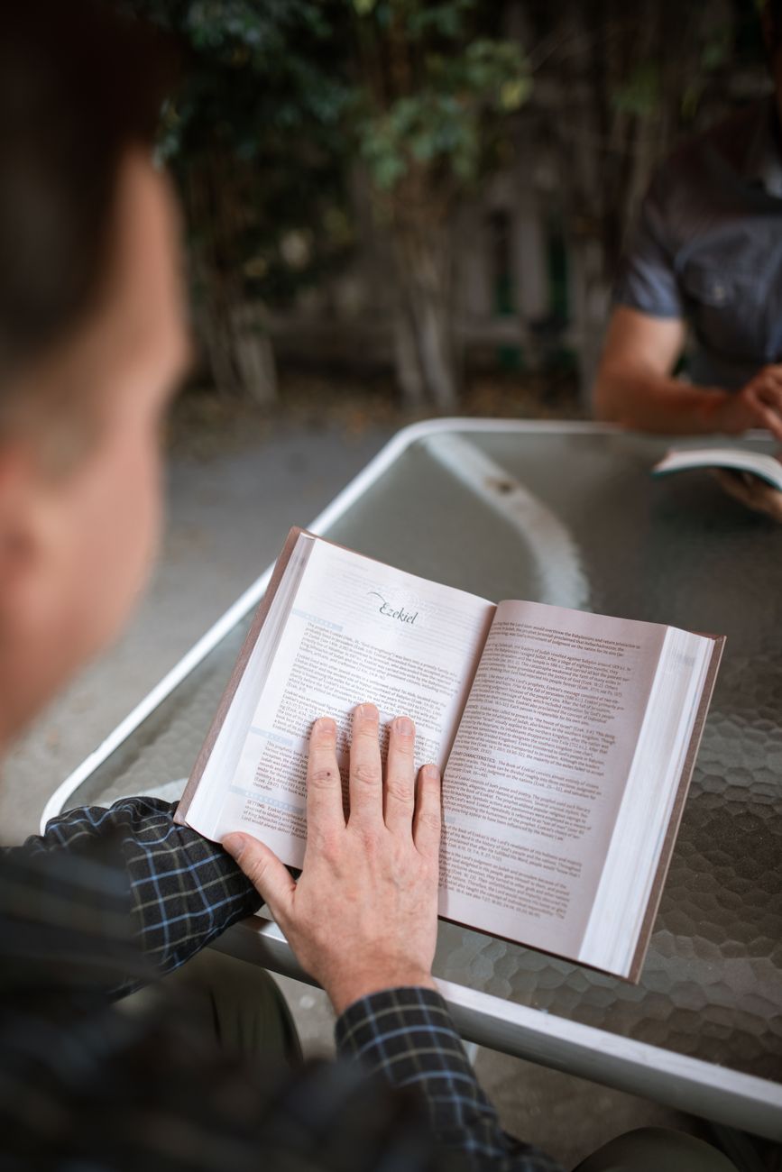 Person highlighting text in an ESV Bible with study notes open beside it