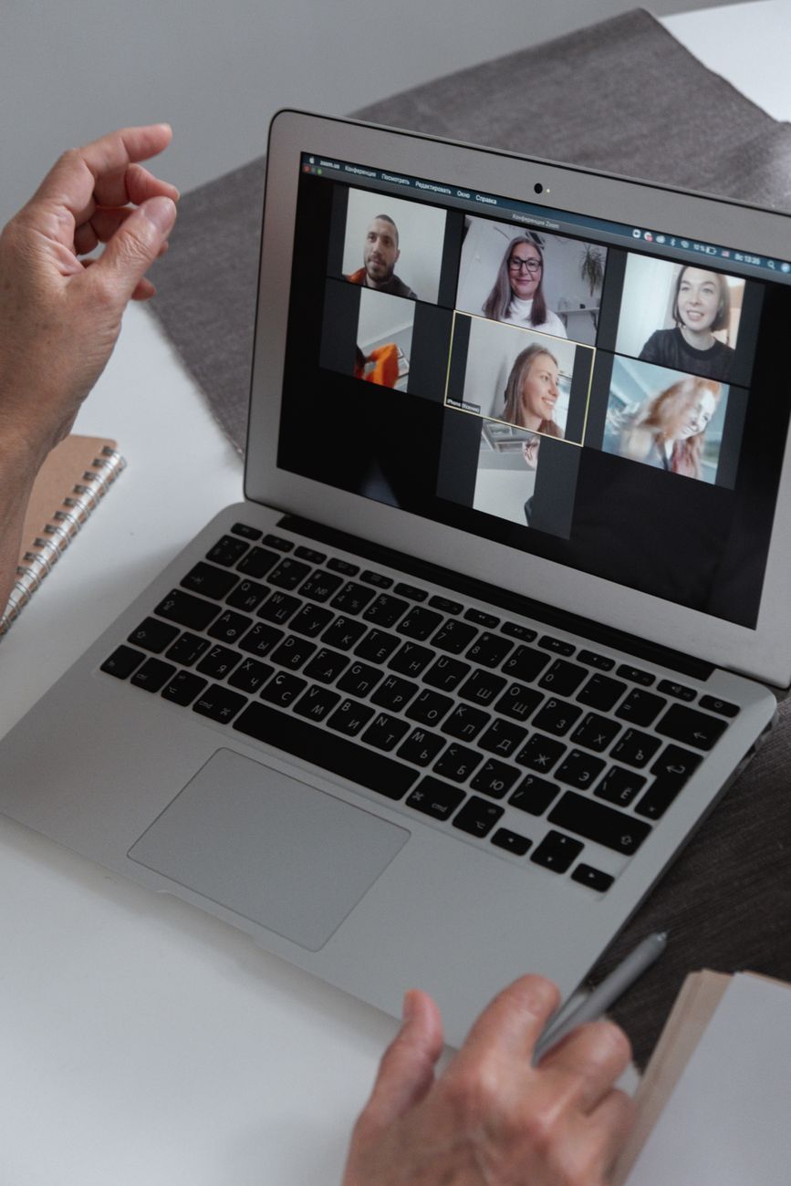 Small group of Christians gathered around laptops for an online Bible study session