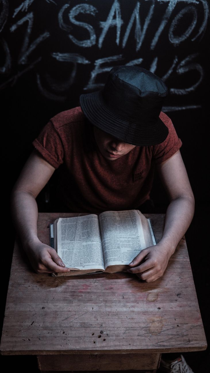 Open Bible on a wooden desk with a notebook and pen beside it