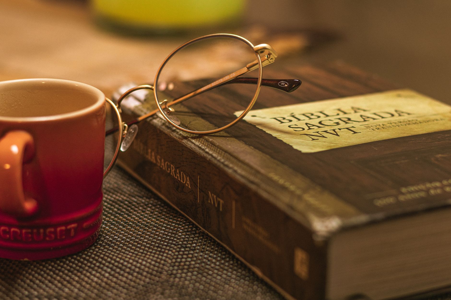 NKJV Bible open on a wooden table with reading glasses beside it