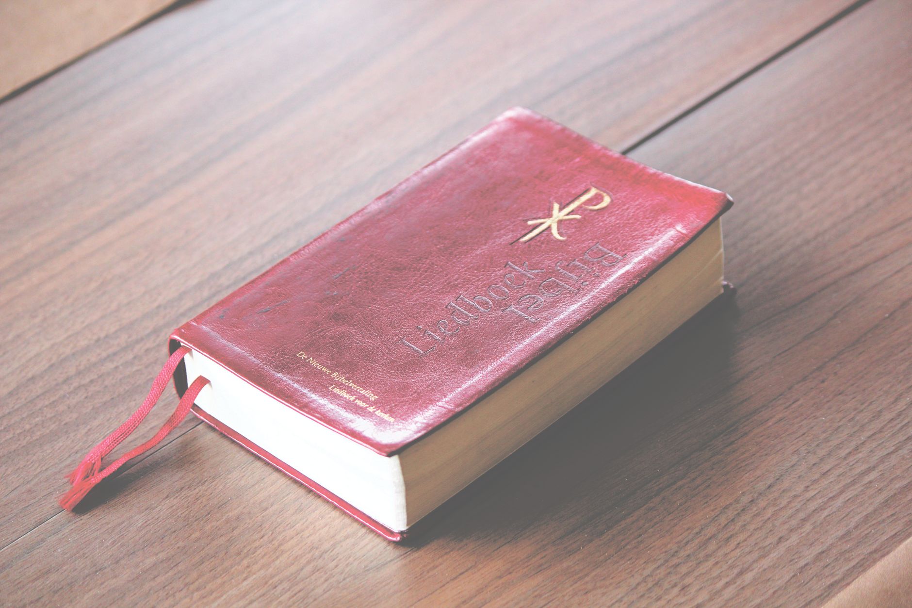 Open commentary book beside a highlighted Bible on a study table