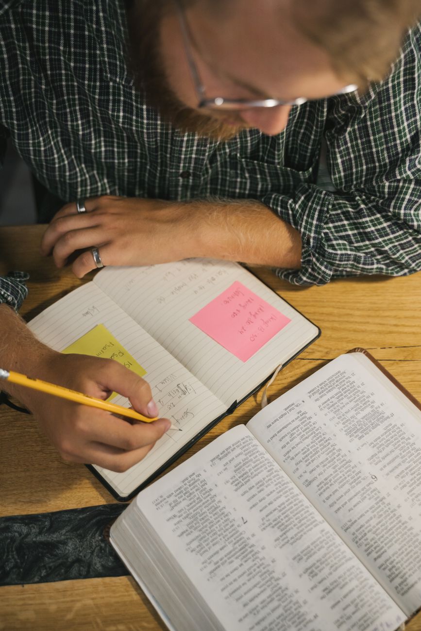 Open Bible study journal next to a smartphone showing connected scripture passages