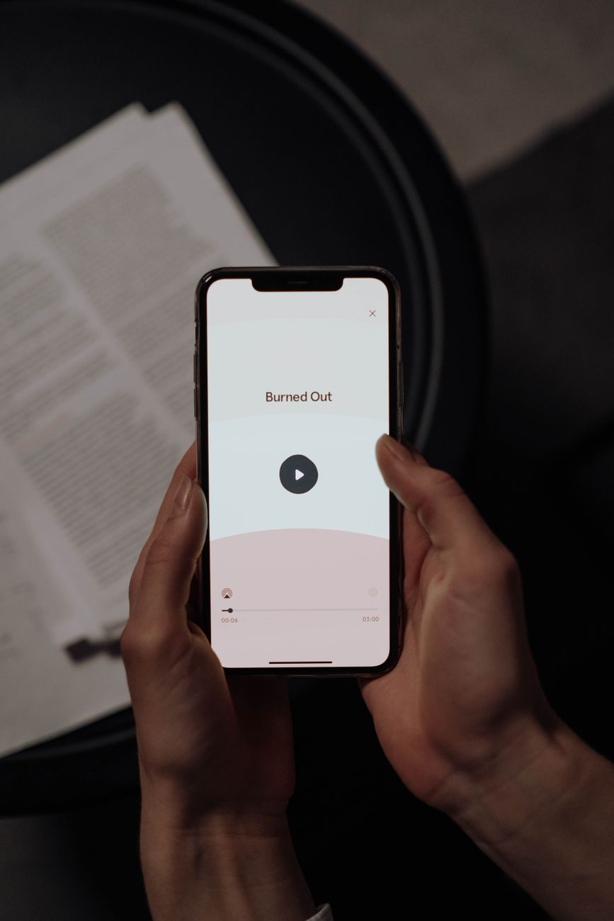 Person holding smartphone reading a Bible study app on a cozy couch
