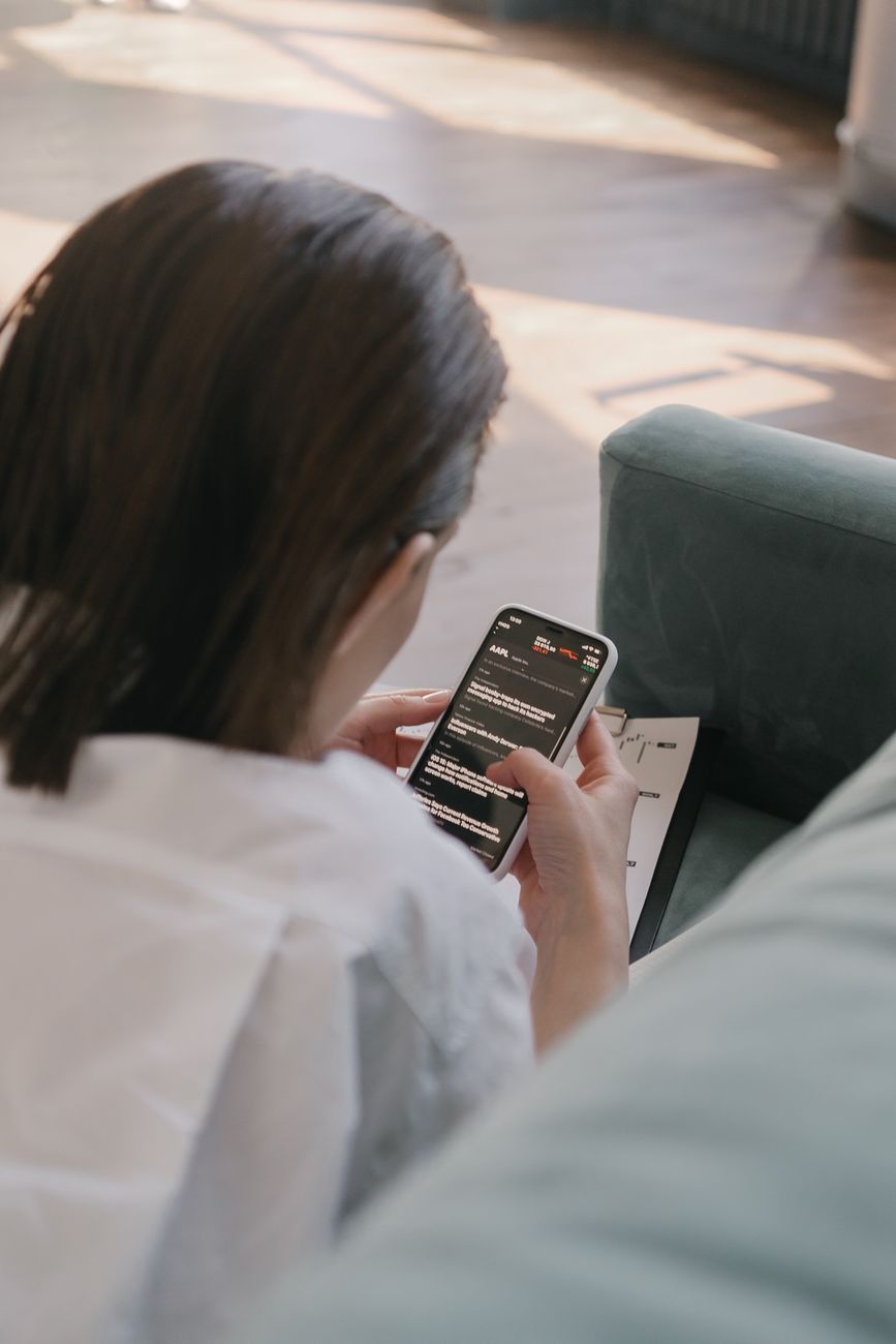 Person studying the Bible on a smartphone app with coffee nearby
