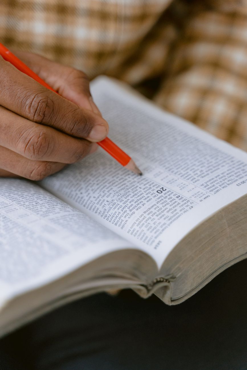 Person studying the Bible with notes and a cup of coffee