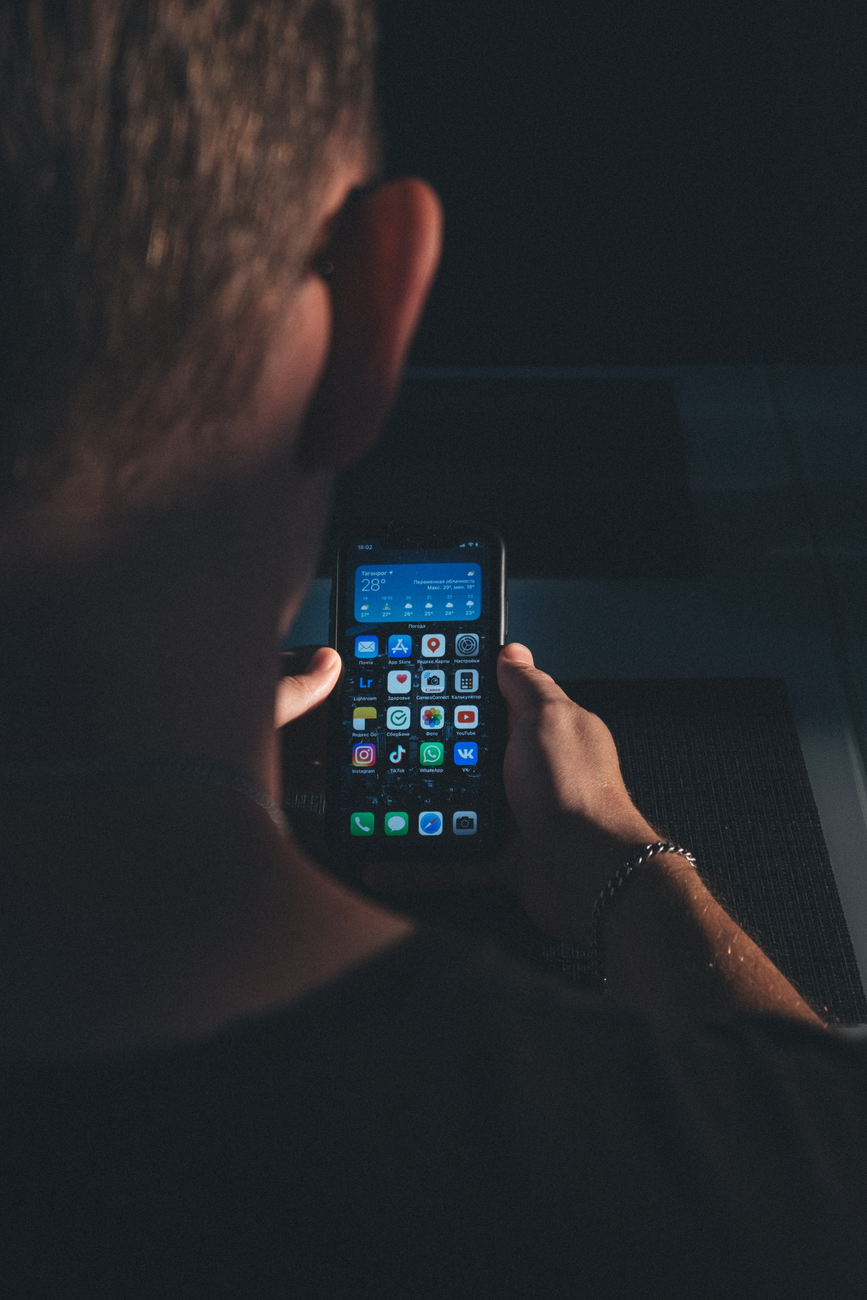 Person reading the Bible on a smartphone with a cup of coffee nearby