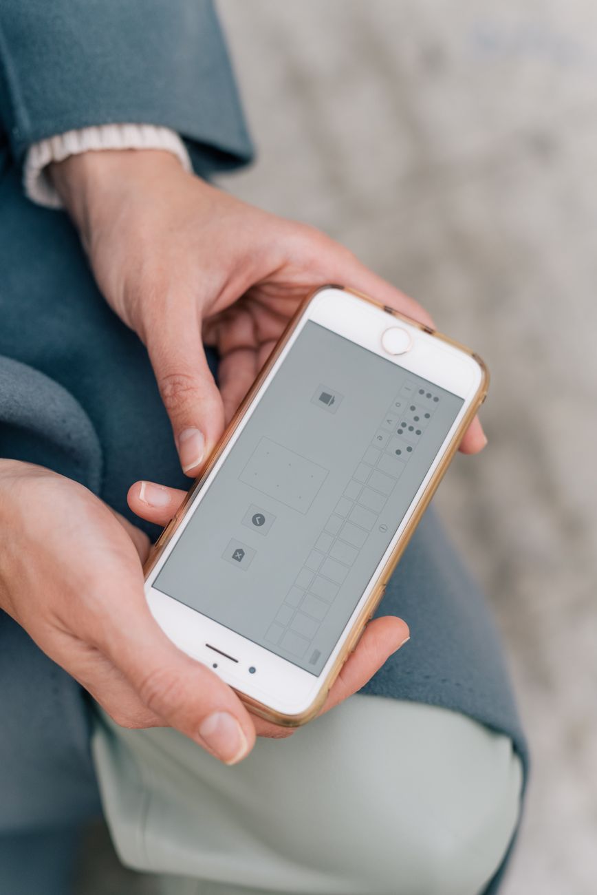 Close-up of hands holding a phone with a colorful Bible app interface