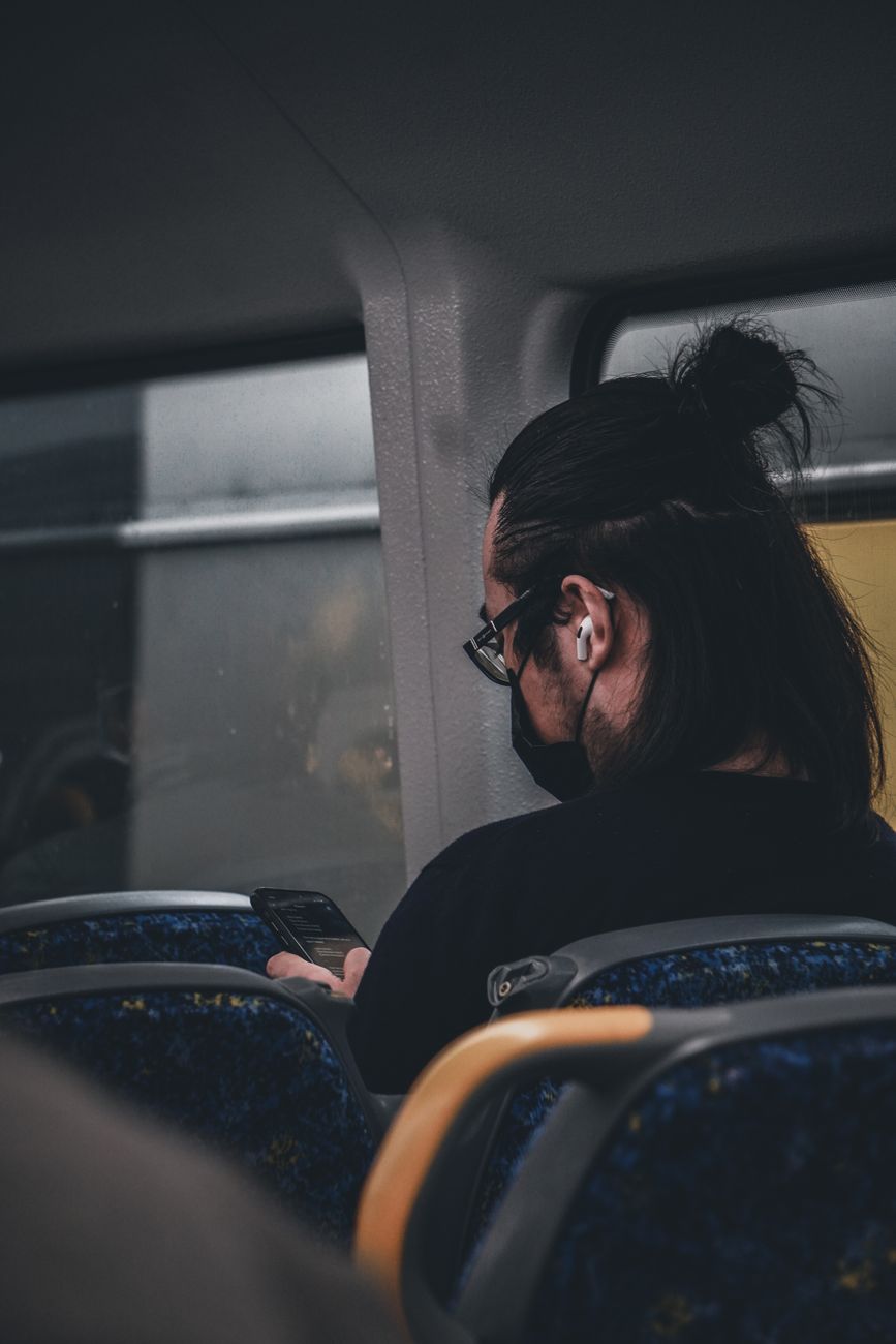 Person listening to Bible audio on smartphone during morning commute