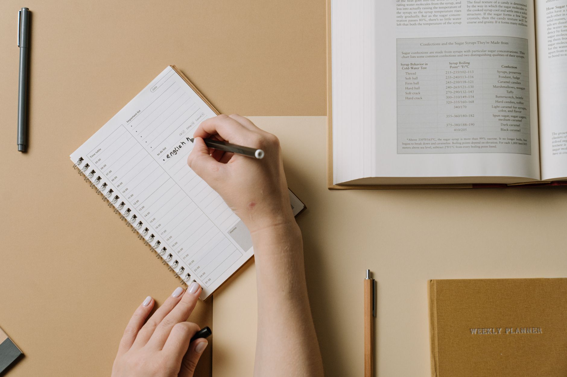 Open Bible next to a daily planner and a pen showing a reading schedule
