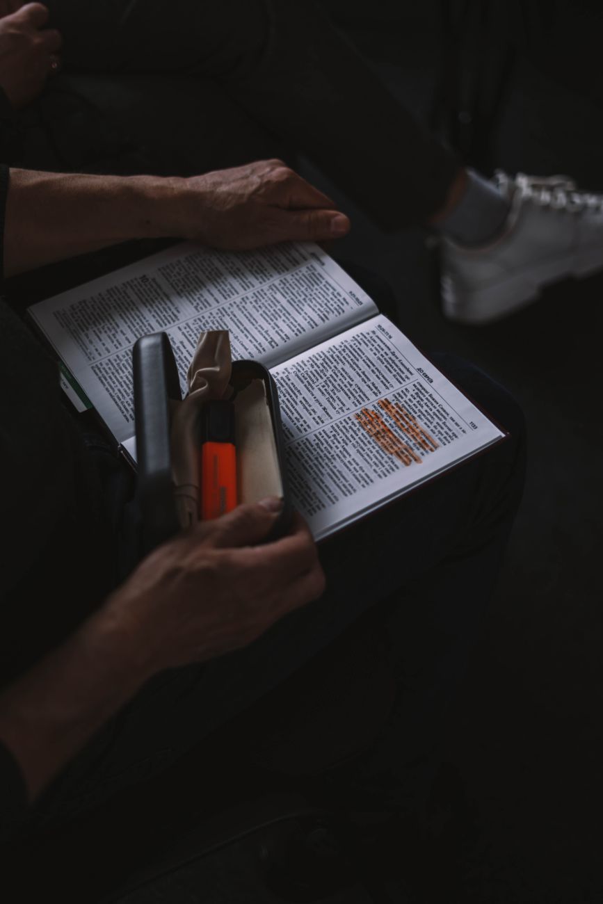 Person studying Bible with highlighted notes on topics like faith and prayer