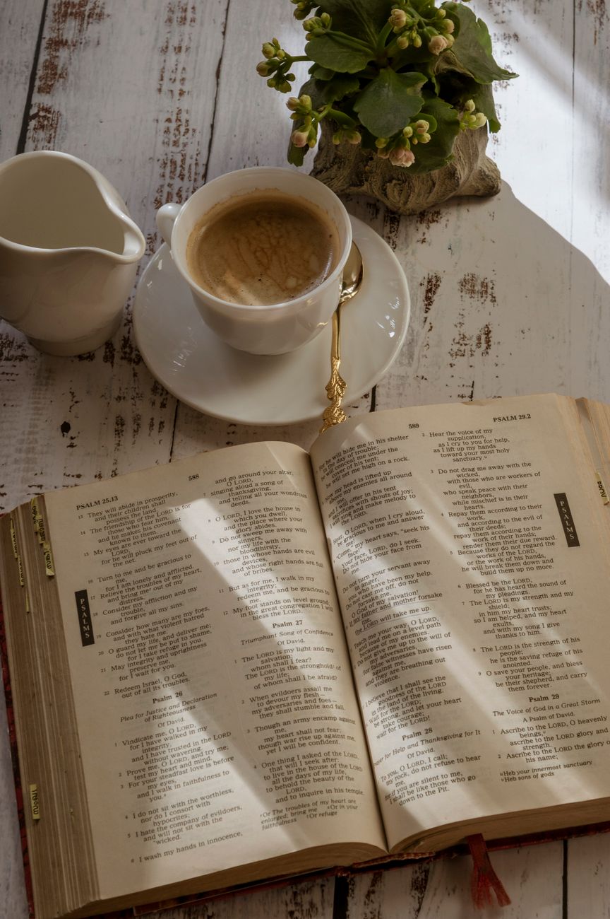 Person reading Bible on a Sunday morning by a window with sunlight