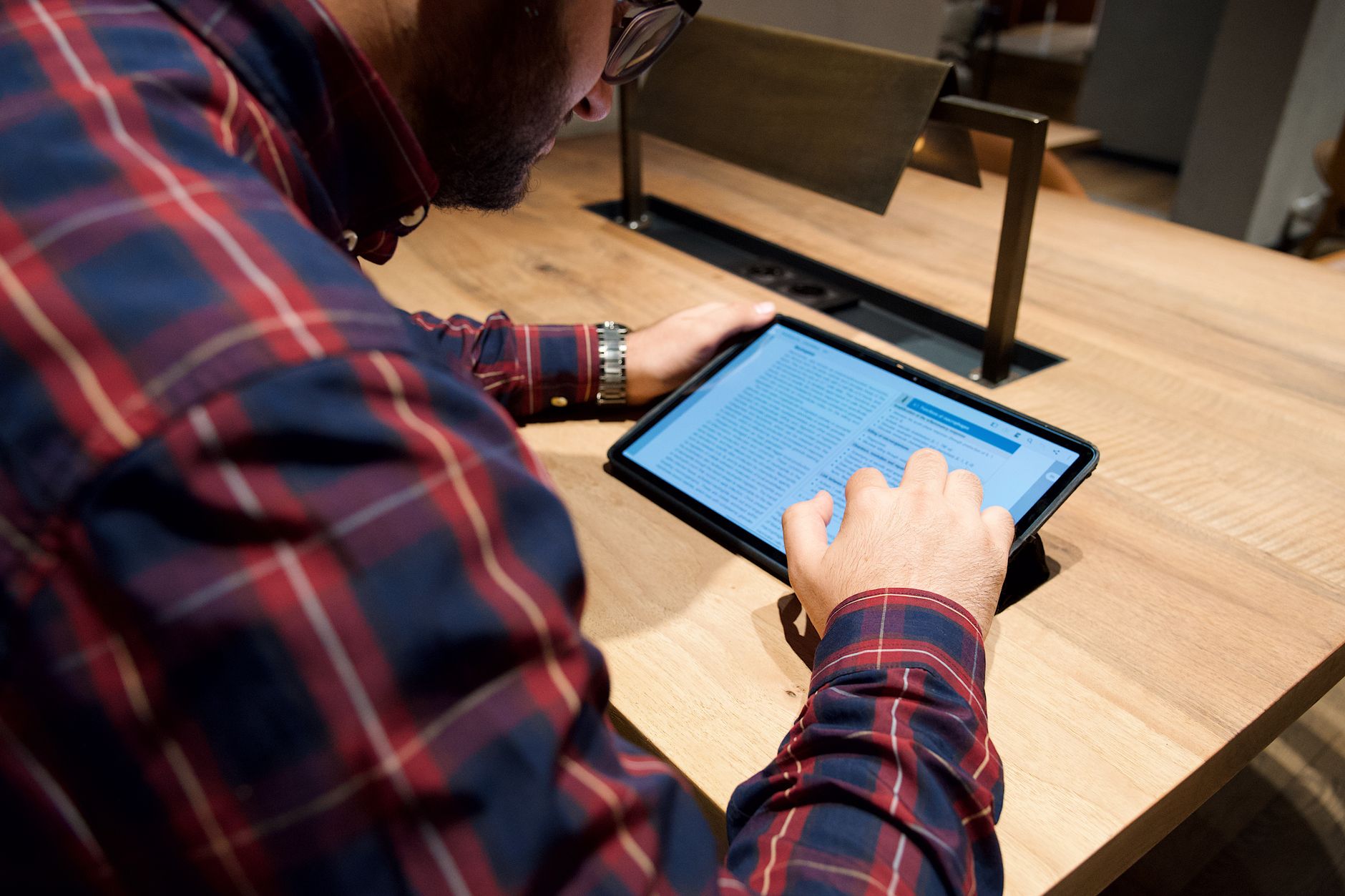 Person using a Bible study app on tablet with cross-reference links highlighted