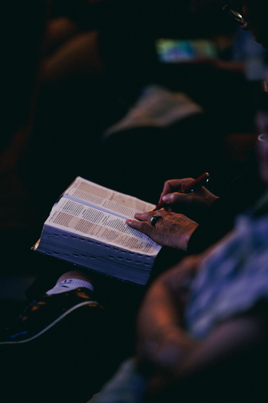 Person studying Bible on a smartphone with cross-reference notes visible
