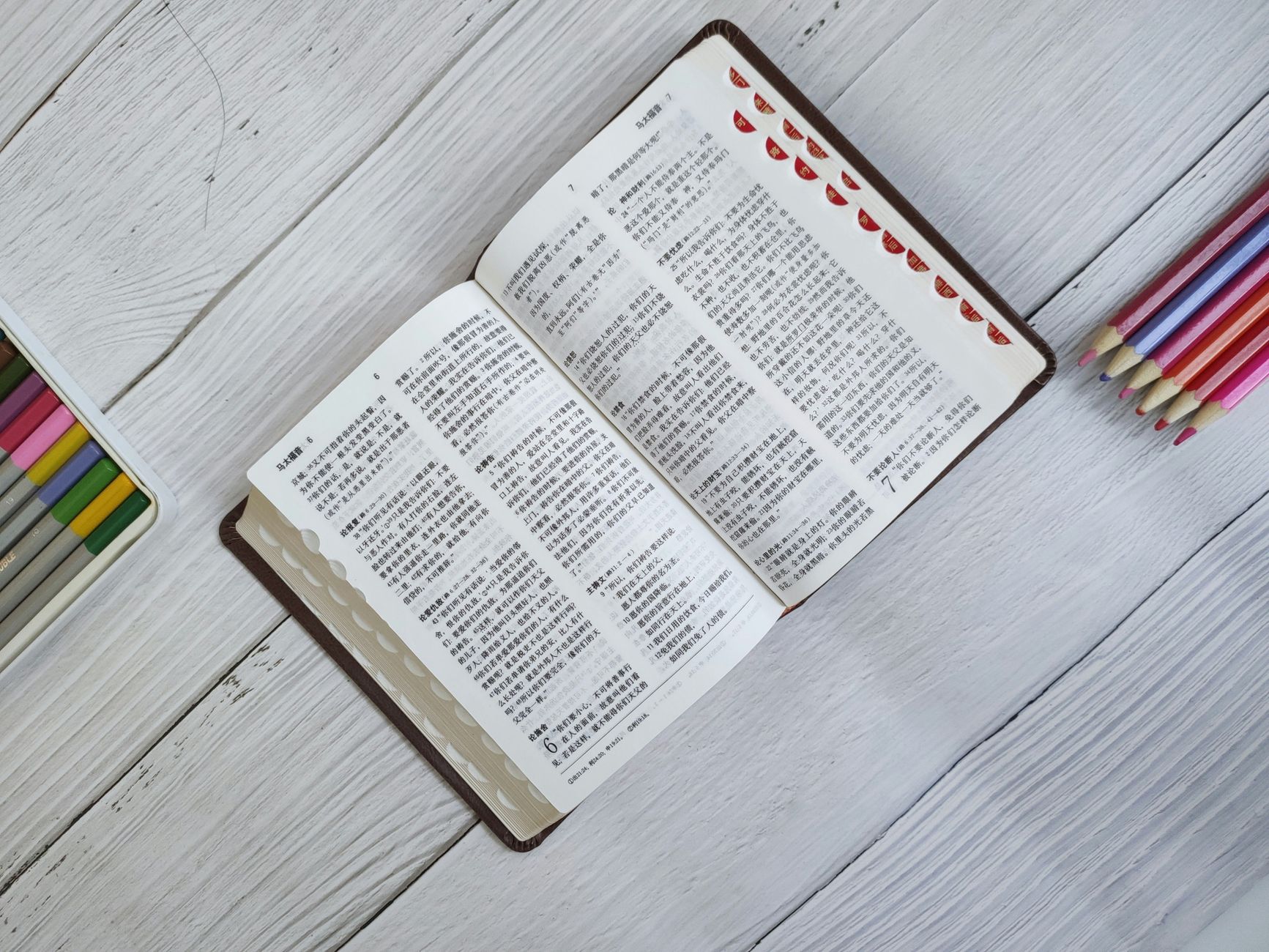 Open Bible with highlighted cross references and study notes on a wooden desk