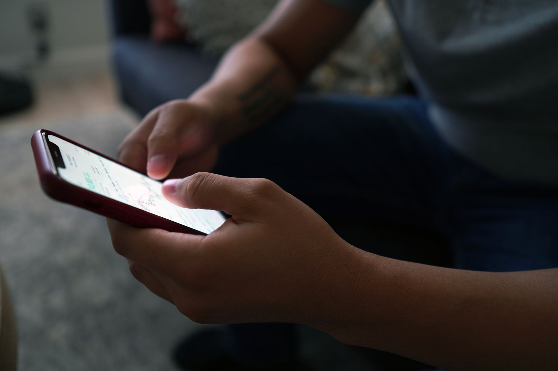Person reading Bible on phone with cross reference app open beside a coffee cup