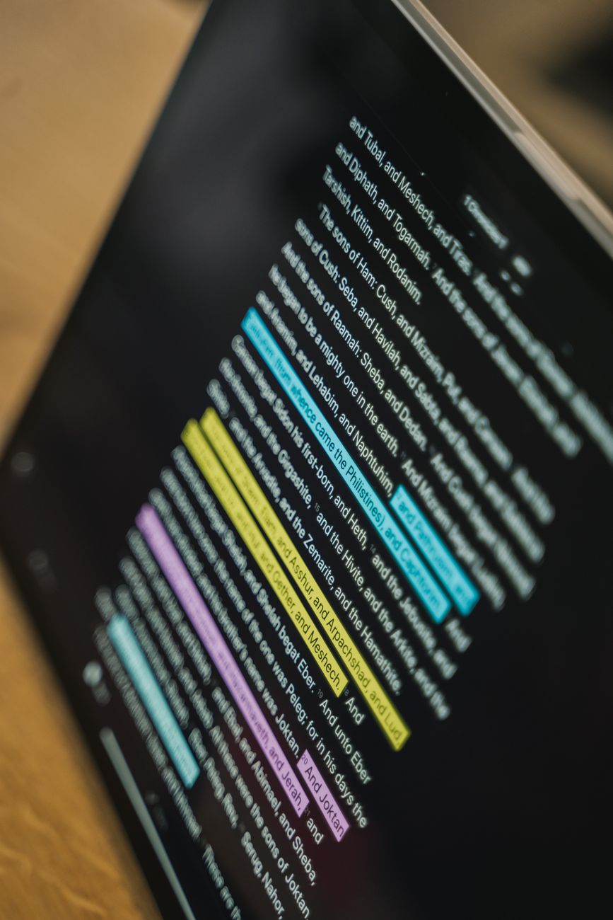 person using bible study app with notebook taking notes
