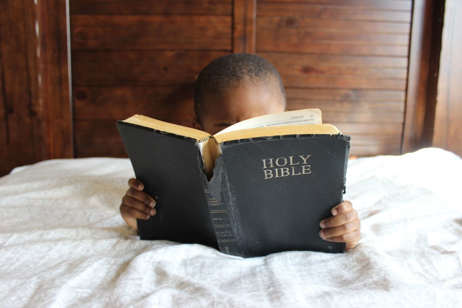 Child reading colorful Bible with simple illustrations