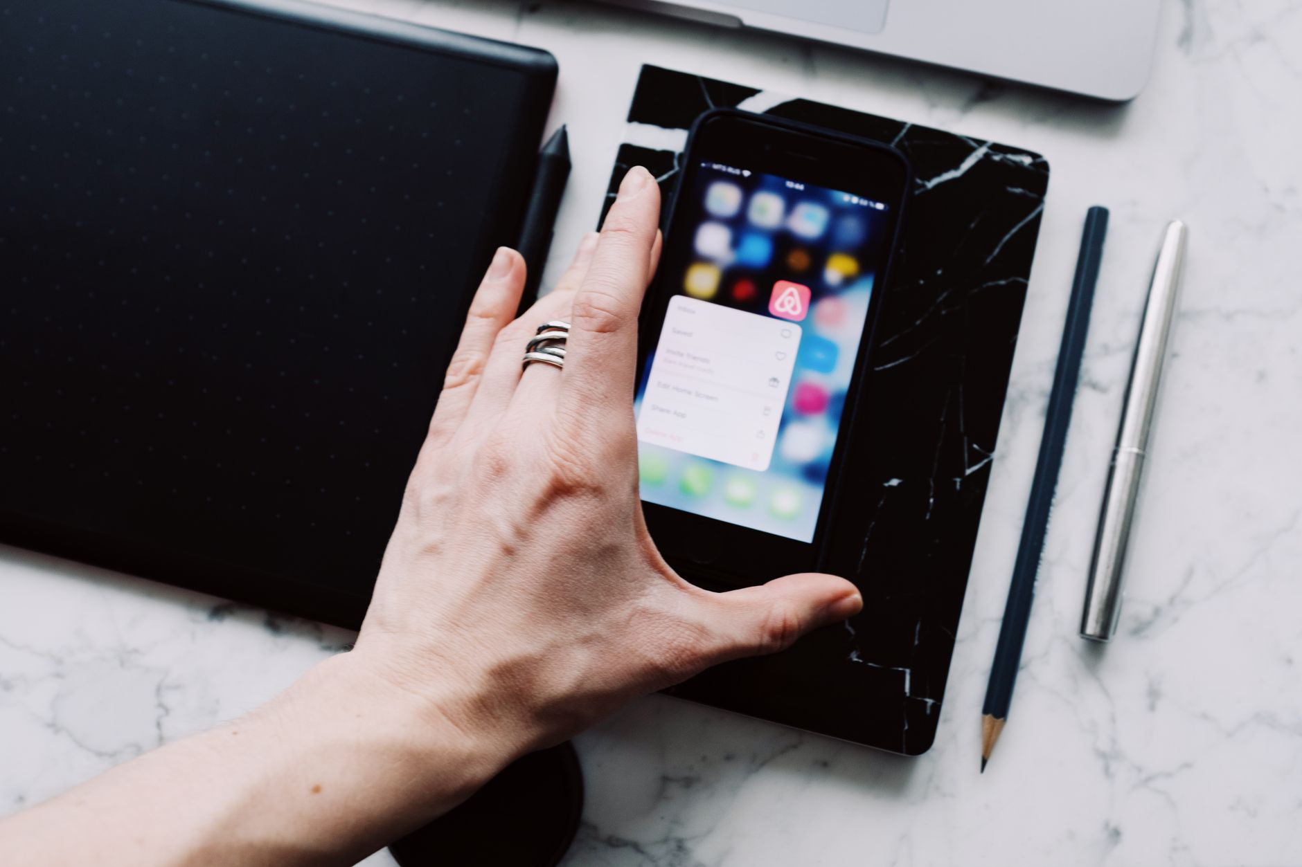 Person studying the Bible on a smartphone app with notes and coffee on a desk